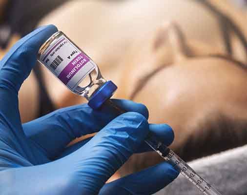 Closeup of a botulinum toxin bottle and syringe