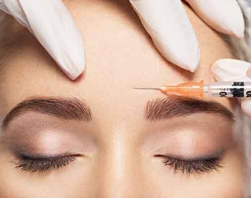 Woman getting BOTOX® injected into her forehead